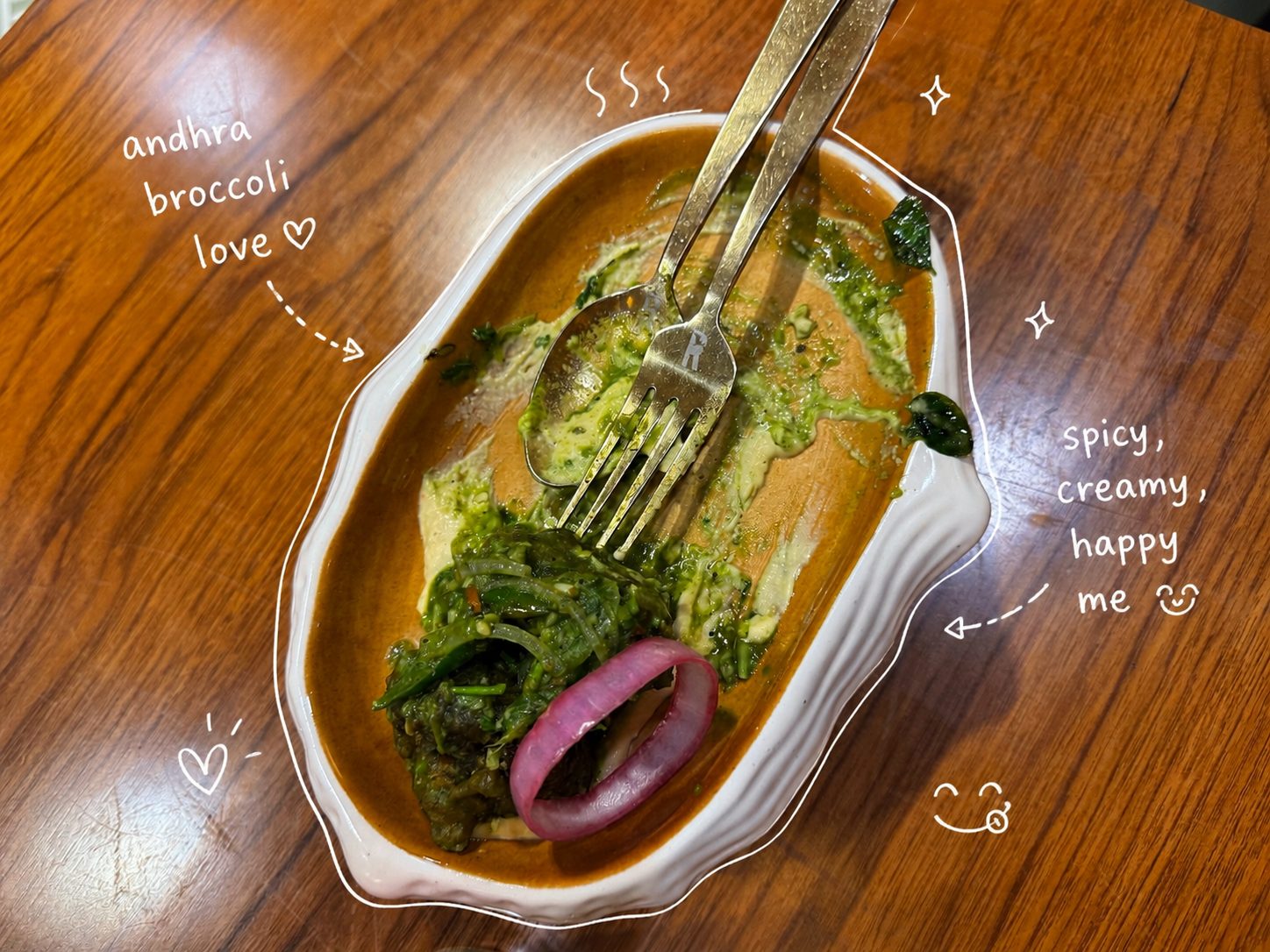 Partially eaten Andhra broccoli with doodle notes on a wooden table
