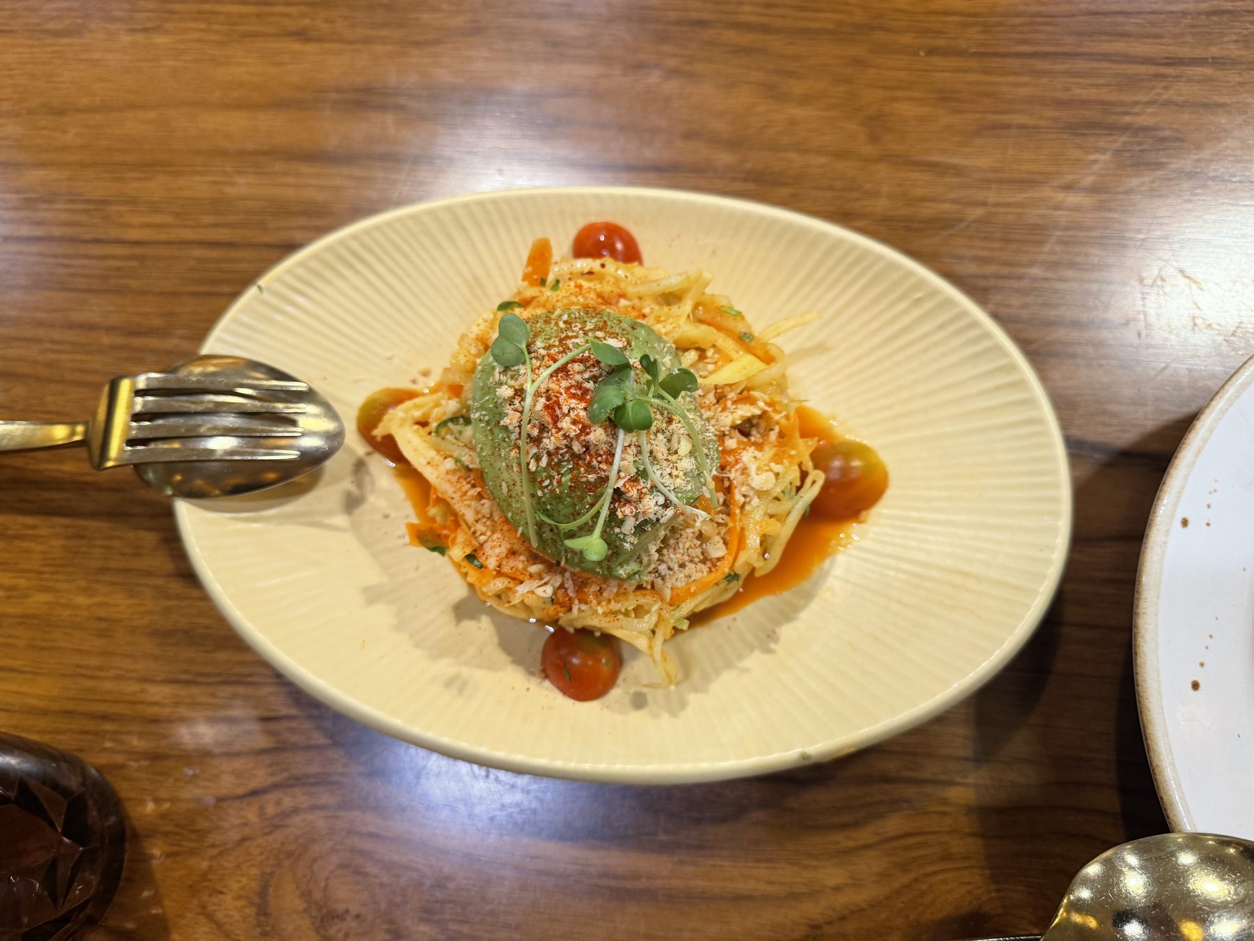 Shredded papaya salad topped with avocado and cherry tomatoes