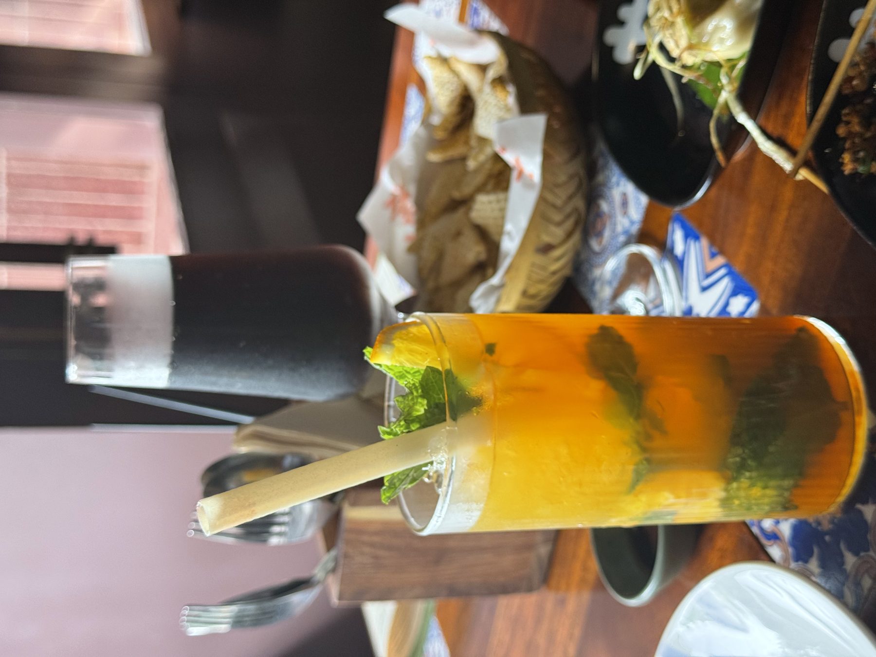 Bright orange iced drink and dark foamy beer on a wooden table