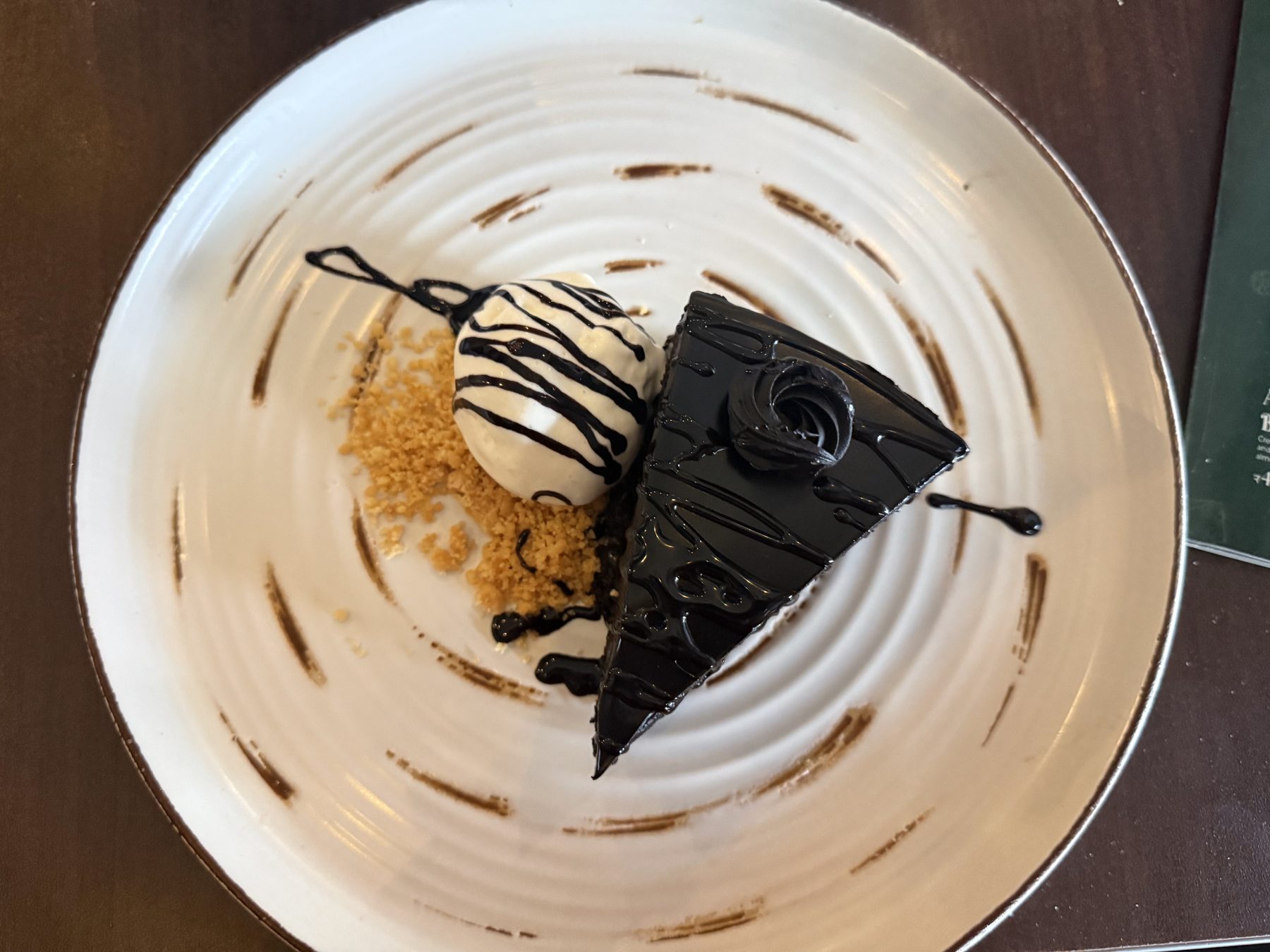 Chocolate cake slice with vanilla ice cream and chocolate drizzle
