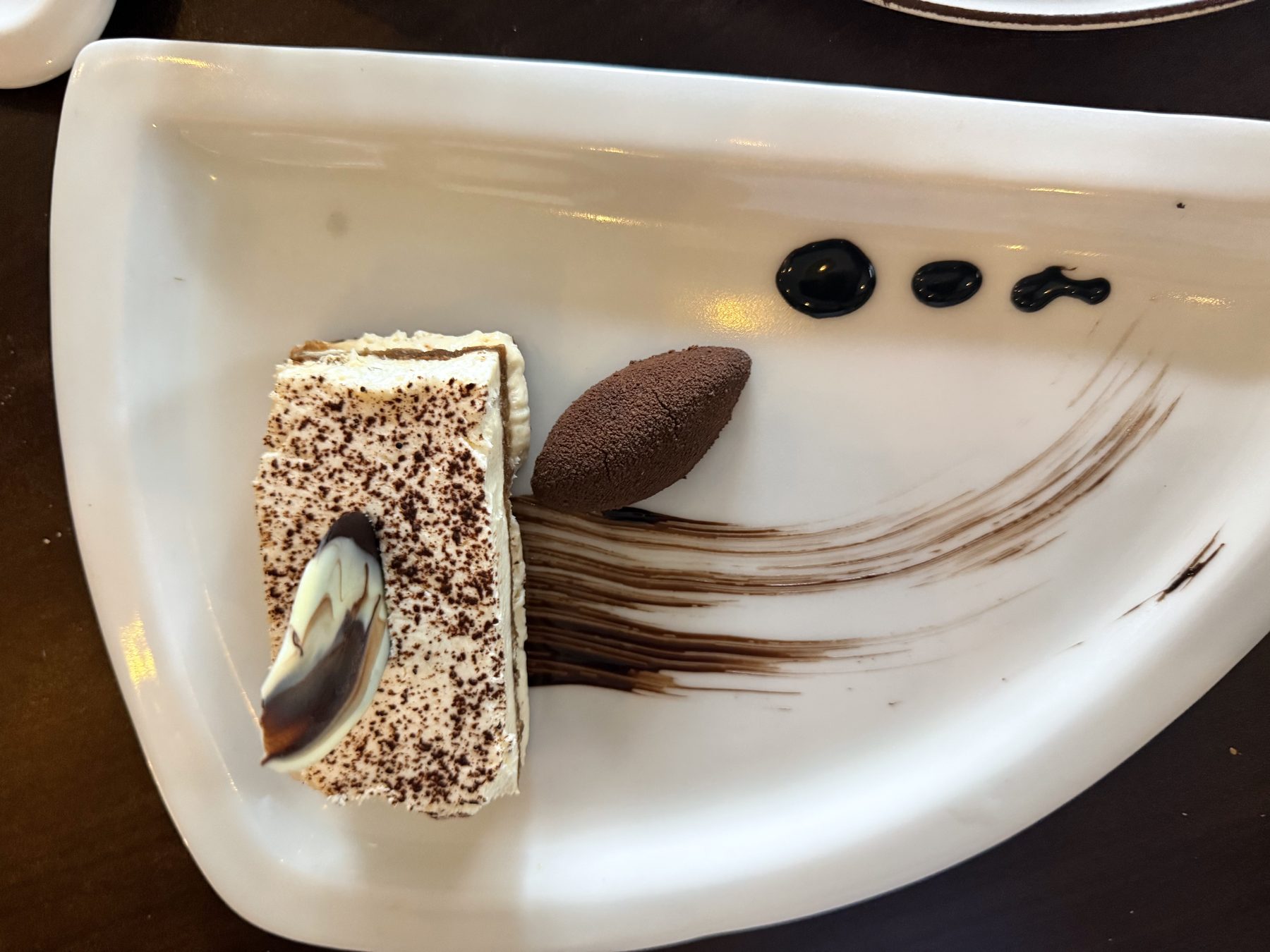 Plated tiramisu with chocolate mousse and artistic chocolate sauce