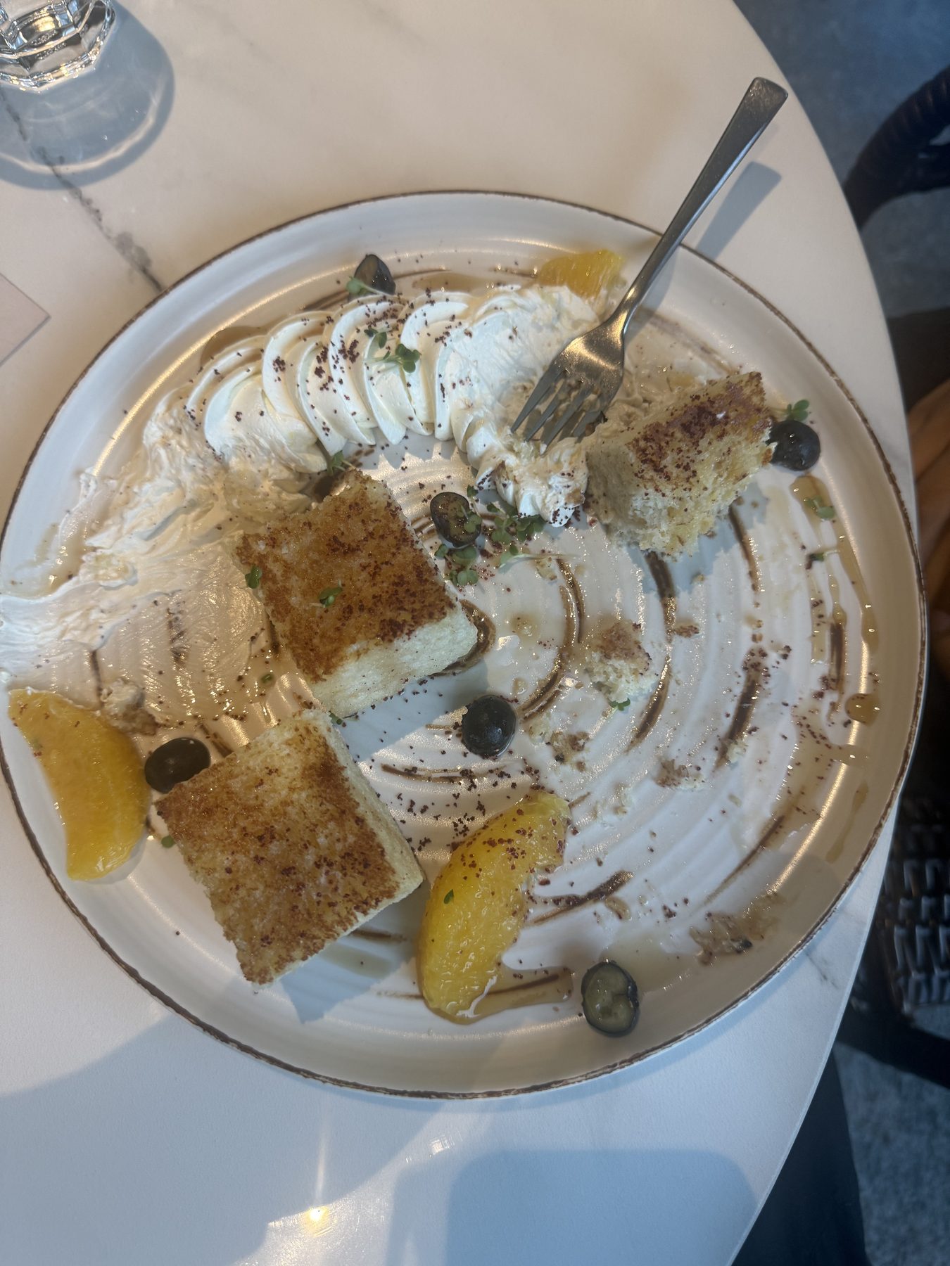 Brunch plate with French toast, whipped cream, orange, and blueberries